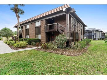 Two-story condo building with wood siding, a shingled roof, balconies, and well-maintained landscaping at 600 N Boundary Ave # 115D, Deland, FL 32720