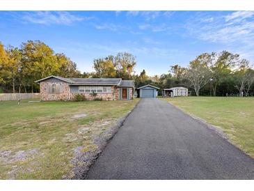 Charming single-story home with brick and siding exterior, featuring a long driveway and detached garage at 753 Glenwood Rd, Deland, FL 32720