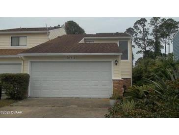 Attached garage with a white door on a two-story home at 1101 Monticello Ln # 3, Port Orange, FL 32129