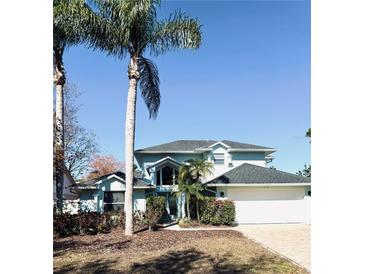 Charming two-story home with a brick driveway, lush landscaping, and beautiful palm trees at 112 Muscovy Ct, Daytona Beach, FL 32119