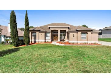 Charming single-story home with a well-manicured lawn, complemented by an elegant fountain and garden at 12736 Lake Ridge Cir, Clermont, FL 34711