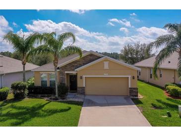 Charming single-story home featuring a two-car garage and well-maintained landscaping with palm trees at 1750 Savannah Ln, Port Orange, FL 32128