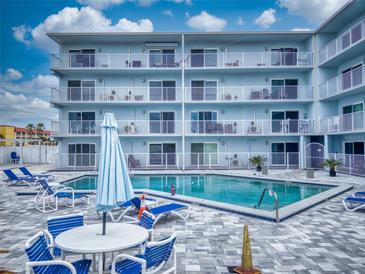 Bright condo building offers a luxurious pool with plenty of seating for residents to relax and enjoy the sun at 3700 S Atlantic Ave # 111, New Smyrna Beach, FL 32169