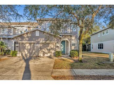 Charming two-story townhome featuring a two-car garage, neutral paint, and an inviting arched doorway at 601 Mount Olympus Blvd, New Smyrna Beach, FL 32168