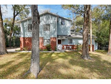 Charming two-story home with light blue siding, red brick, and a well-maintained front yard at 749 E Wisconsin Ave, Orange City, FL 32763