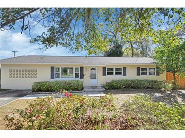 Charming single-story home with blue shutters, flower beds and light-yellow painted exterior at 141 N Mcdonald Ave, Deland, FL 32724