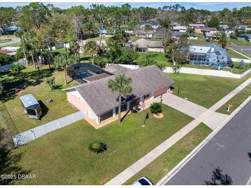 Home exterior featuring a pool, screened patio, trailer, mature trees, and well-maintained landscaping at 1489 Casey Ln, Port Orange, FL 32129