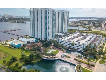 Expansive aerial view of a luxury condominium complex with manicured grounds, fountain, and waterfront access at 231 Riverside Dr # 1702-1, Holly Hill, FL 32117