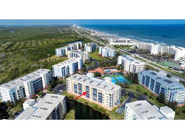 Stunning aerial view of beachfront condo complex with pool, tennis courts, and ocean views at 5300 S Atlantic Ave # 8-404, New Smyrna Beach, FL 32169