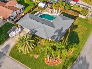 Aerial view of a home with a well-manicured lawn, complemented by a pool and a boat in the driveway at 1424 Breaks Way, Port Orange, FL 32127