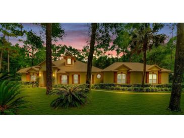 Charming one-story home with well-maintained lawn, beautiful shrubbery, and mature trees at 1875 Glenwood Oaks Ln, Deland, FL 32720