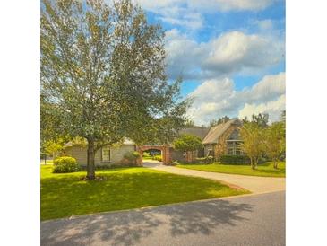 Inviting single story home with well maintained lawn, mature trees, and brick accents on driveway and covered walkway at 238 Crooked Tree Trl, Deland, FL 32724