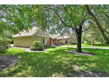 Side view of home with a detached garage and beautifully landscaped yard with large trees at 238 Crooked Tree Trl, Deland, FL 32724