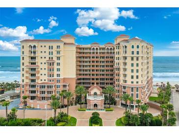 Stunning exterior view of a beachfront condominium with meticulous landscaping and beautiful blue skies at 2515 S Atlantic Ave # 401, Daytona Beach Shores, FL 32118