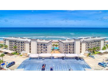 Stunning aerial view of beachfront condos with a pool, parking, and ocean views at 2700 Ocean Shore Blvd # 305, Ormond Beach, FL 32176