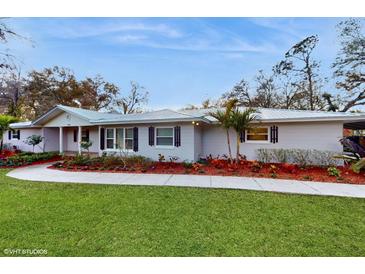 Charming one-story home with well-manicured lawn, walkway, and lush landscaping at 7108 East Rd, Lakeland, FL 33809