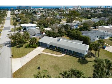 Aerial view of a charming home showcasing its well-manicured lawn, established landscaping, and inviting curb appeal at 72 Rockefeller Dr, Ormond Beach, FL 32176