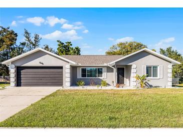 Charming single-story home with a well-manicured lawn, neutral siding, and an attached two-car garage at 755 Fairlawn Dr, Orange City, FL 32763