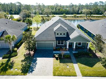Stunning lakefront home with a three-car garage, paver driveway, and manicured landscaping at 1204 Draycott St, Ormond Beach, FL 32174