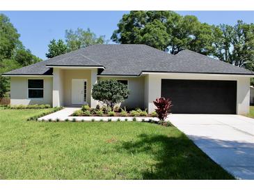 Charming single-story home featuring a well-manicured lawn, inviting entryway, and a spacious two-car garage at 1275 16Th St, Orange City, FL 32763