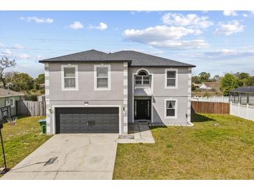 Two-story home featuring a two-car garage and a well-maintained lawn at 1978 S Old Mill Dr, Deltona, FL 32725
