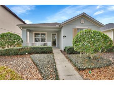 Charming one-story home featuring a covered porch and lush landscaping in a well-maintained front yard at 203 W Tarrington Dr, Deland, FL 32724