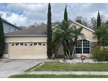 Charming single-story home featuring stone accents, a two-car garage, and lush landscaping at 2238 Windcrest Lake Cir, Orlando, FL 32824