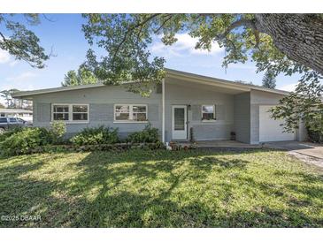 Charming single-story home with a well-maintained lawn and mature trees providing shade at 2821 Oak Lea Dr, South Daytona, FL 32119