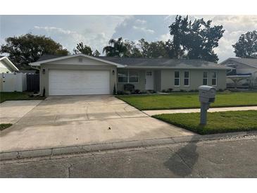 Charming single-story home features a well-manicured lawn, tidy landscaping, and an attached two-car garage at 2929 Carriage Dr, South Daytona, FL 32119