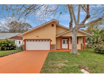 Inviting single Gathering home featuring a two-car garage and charming front porch with decorative columns at 926 Sycamore St, Daytona Beach, FL 32114