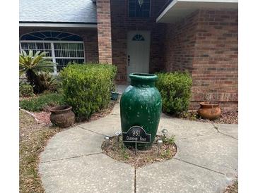Charming home exterior with landscaped front yard and decorative urn at 961 Oakwood Rd, Orange City, FL 32763