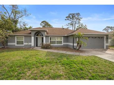 Charming single-story home with a well-maintained lawn and neutral gray exterior paint at 1576 Naples Cir, Deltona, FL 32738