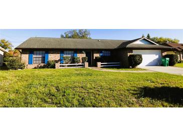Charming brick home with blue shutters and well-maintained front yard at 1013 Matterhorn St, Deltona, FL 32725