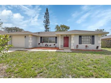 Charming single-story home with a red front door and manicured landscaping at 1033 Windbrook Dr, Deltona, FL 32725