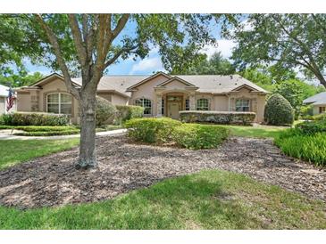 Well-maintained home with lush landscaping, a sidewalk, and stone accents on the facade at 1491 W Silver Hammock, Deland, FL 32720