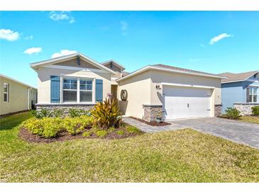 Charming single Gathering home featuring a well maintained lawn, an attached garage, and stone veneer accents at 1716 Red Rock Rd, New Smyrna Beach, FL 32168