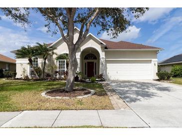 Charming single-story home featuring a well-manicured lawn, mature trees, and a welcoming two-car garage at 1751 Creekwater Blvd, Port Orange, FL 32128