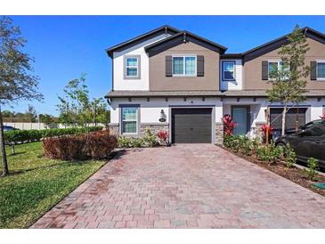 Charming townhome featuring brick paver driveway and manicured landscaping at 206 Beautyberry Ln, Sanford, FL 32771