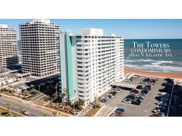 View of The Towers Condominiums with a large parking lot and easy beach access at 2800 N Atlantic Ave # 116, Daytona Beach, FL 32118