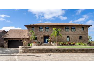 Elegant brick home featuring a grand entrance with mature landscaping and a large driveway at 2852 John Anderson Dr, Ormond Beach, FL 32176