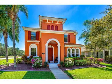 Inviting Mediterranean-style home with vibrant colors, lush landscaping and a well-manicured lawn at 3346 Pegaso Ave, New Smyrna Beach, FL 32168