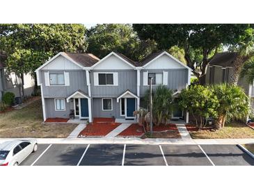 Two-story townhome with gray siding, white trim, a brown roof, well-manicured landscaping, and ample parking at 3960 Willow Trail Run # 45, Port Orange, FL 32127