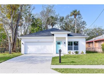 Charming single-story home with a white exterior, attached garage, and well-manicured front yard at 414 Ellsworth St, Daytona Beach, FL 32114