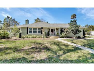 Charming single-story home with a well-manicured lawn and inviting front porch in a residential neighborhood at 435 N Oak Ave, Orange City, FL 32763