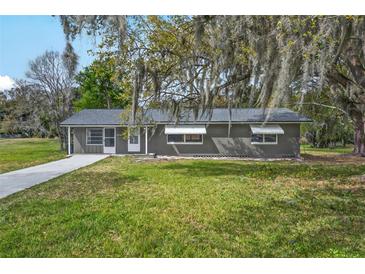 Charming single-story home featuring a well-maintained lawn and mature tree with draping Spanish moss at 512 Power Rd, Sanford, FL 32771
