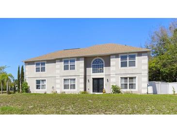 Expansive two-story home boasting a symmetrical facade, large windows, and a meticulously maintained lawn at 707 Leeward Dr, Deltona, FL 32738