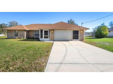 Charming single-story brick home with a well-manicured lawn and a spacious two-car garage at 951 Lovington Dr, Deltona, FL 32738