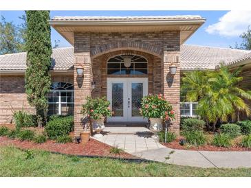 Charming brick home featuring a double door entrance and beautifully landscaped front yard at 1058 W Seagate Dr, Deltona, FL 32725