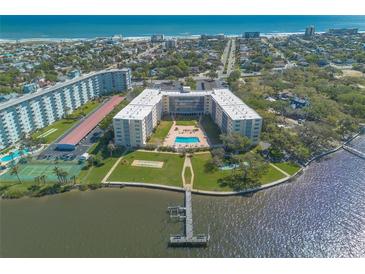 Expansive aerial view of the condo complex, highlighting its pool, tennis courts, waterfront access, and ocean views at 1224 S Peninsula Dr # 210, Daytona Beach, FL 32118