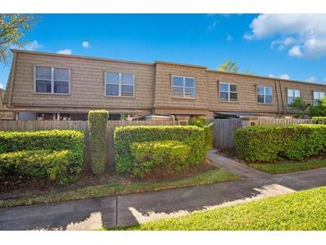 A welcoming multi-Gathering home showcases tidy landscaping with well-manicured shrubs and mature trees at 200 Saint Andrews Blvd # 2804, Winter Park, FL 32792